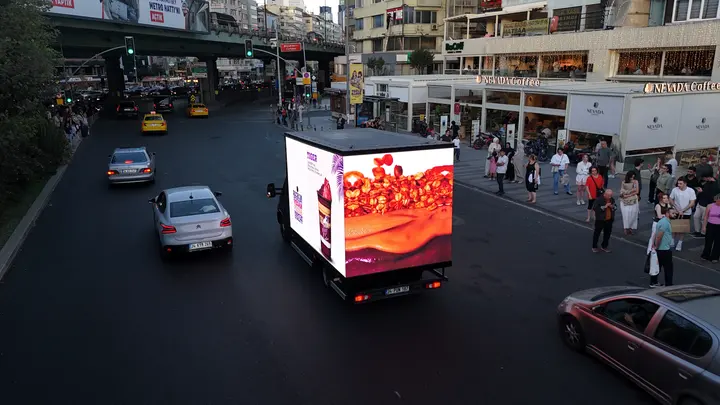 Gece caddede yayın yapan LED reklam aracı
